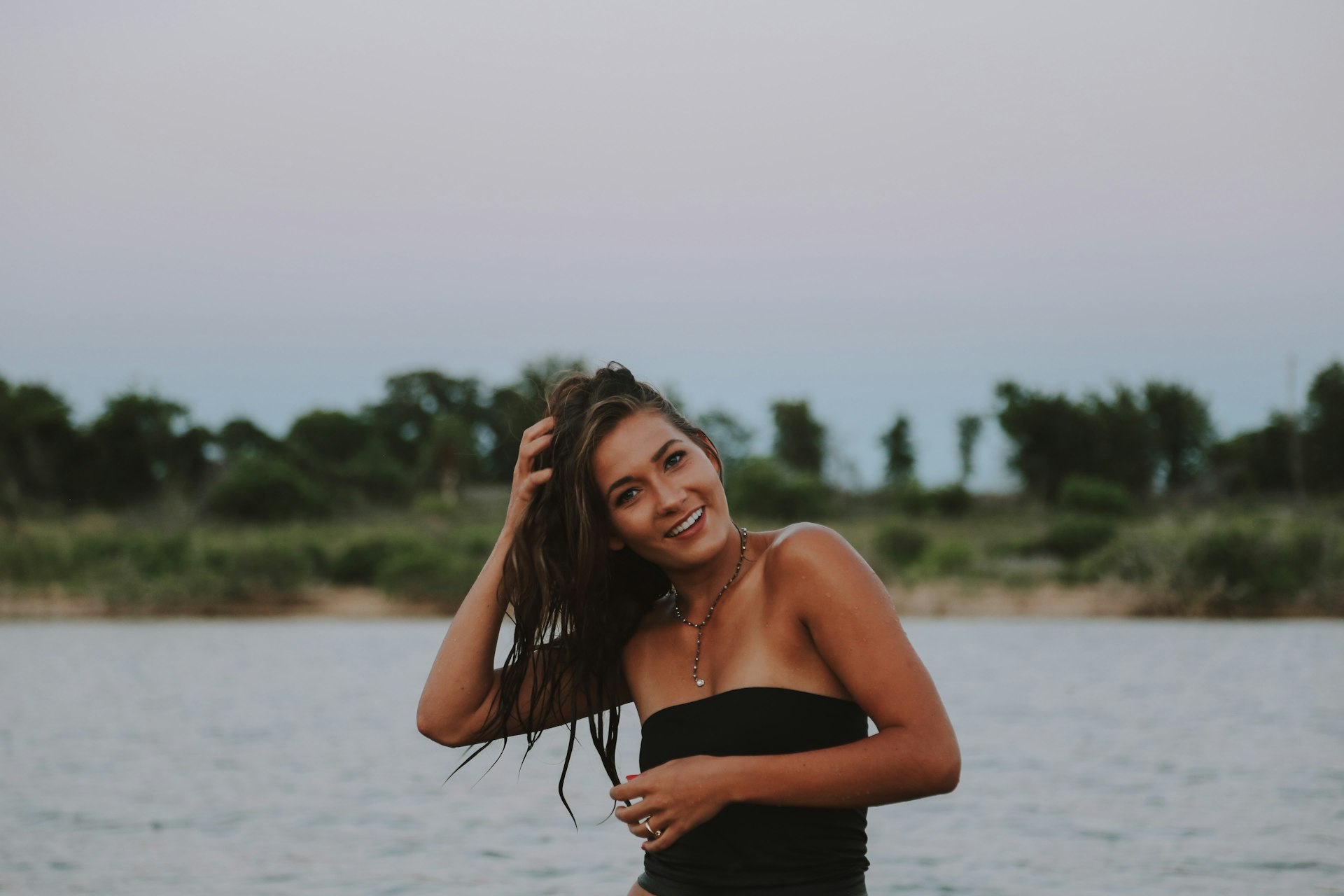woman wearing black strapless tops near body of water